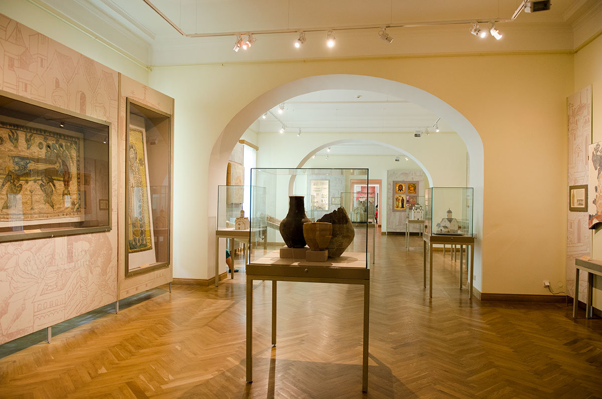 Картины и образцы древней посуды, макеты храмов и редкие вещи в витринах в Новгородском музее