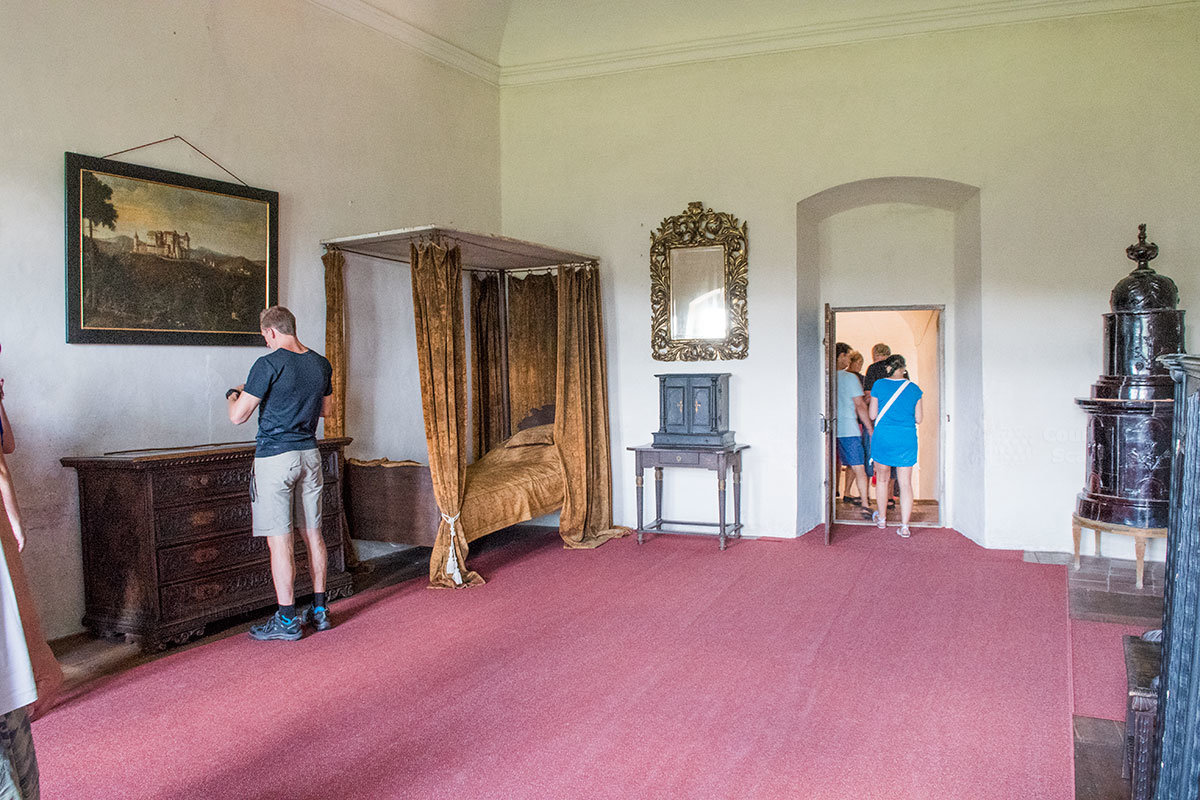 Спальное помещение замка Пернштейн с отопительной печью оригинальной конструкции, топка которой вынесена за пределы комнаты.
