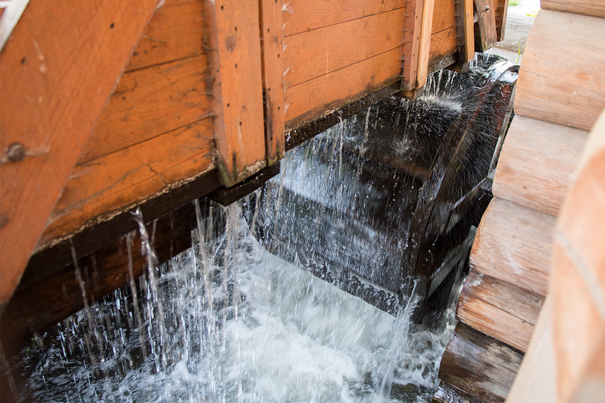 Из водяного желоба мельницы на реке Жуже во все щели хлещет вода, но это только развлекает любознательных и жизнерадостных посетителей.