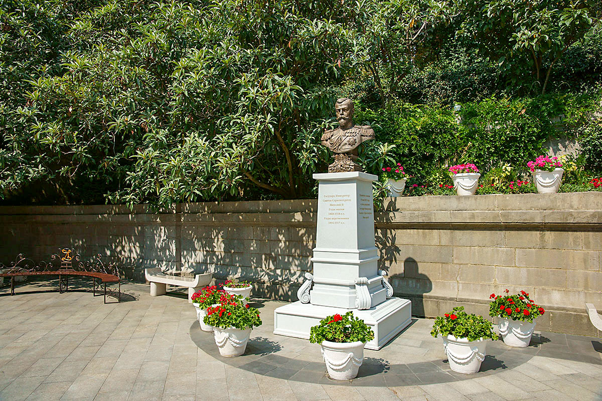 Открытый в 2015 году бюст заказчика Ливадийского дворца, последнего российского императора Николая II, окружен цветущими растениями в горшках.