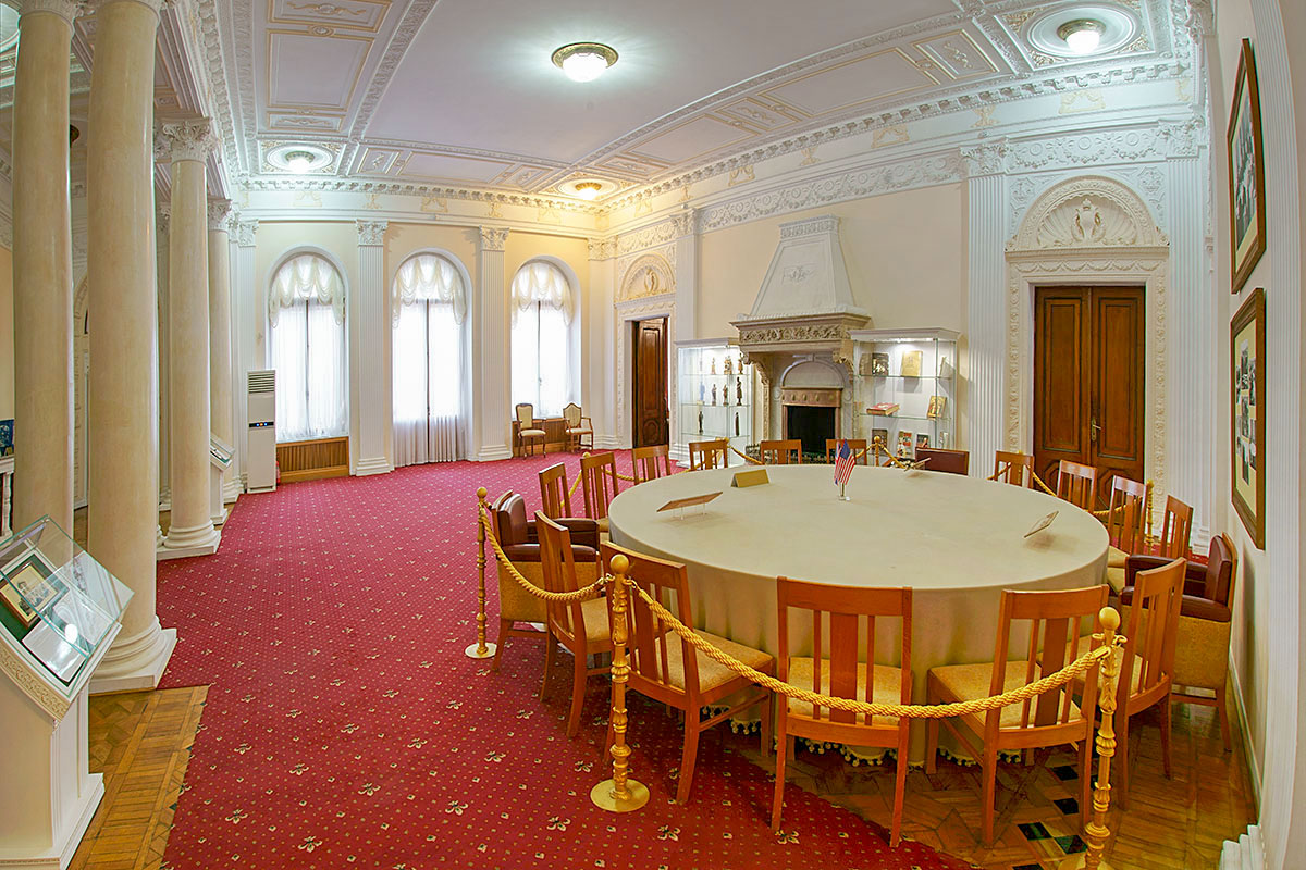 Оформленный колоннами и пилястрами парадный вестибюль Ливадийского дворца демонстрирует круглый стол, использованный при Ялтинской конференции.