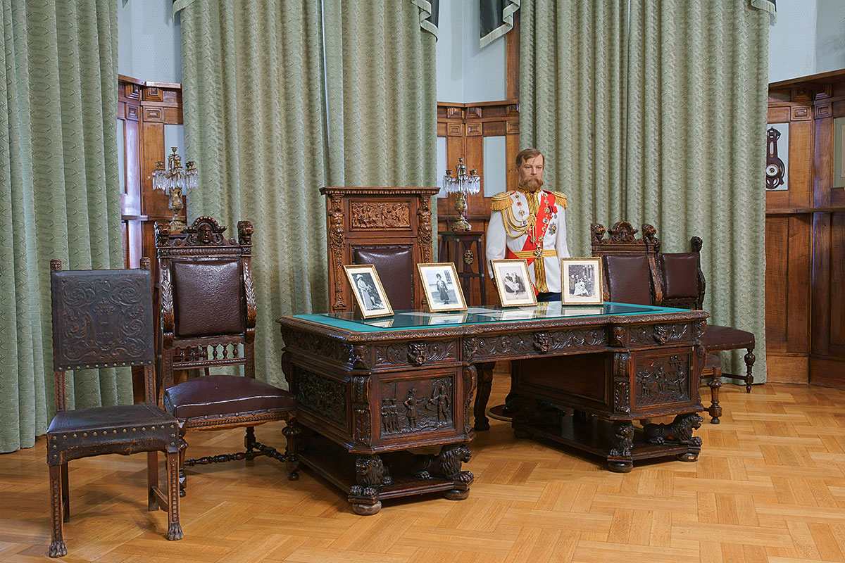 Украшенный филигранной резьбой по дереву императорский стол с манекеном Николая II рядом – одно из ярких украшений Ливадийского дворца.