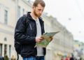 Турист с бумажной картой в Петербурге — город раздаёт путеводители на случай сбоев связи