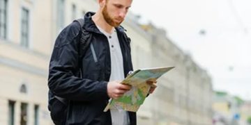 Турист с бумажной картой в Петербурге — город раздаёт путеводители на случай сбоев связи