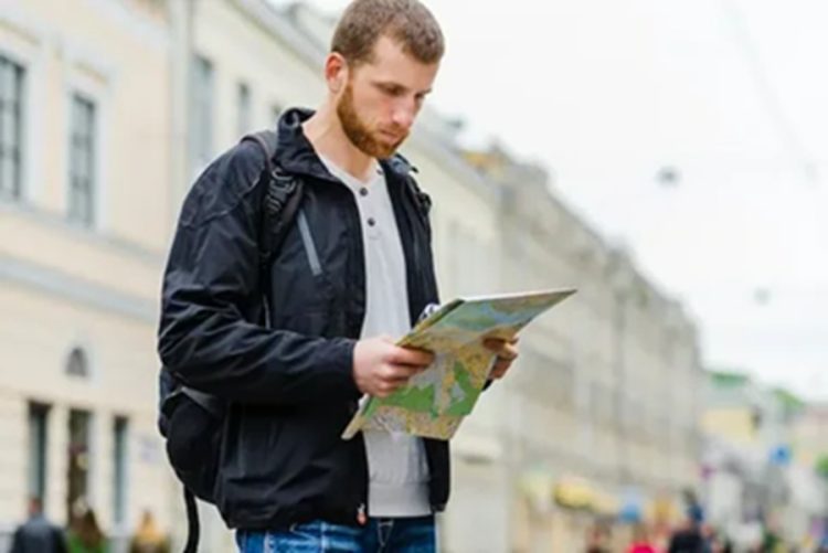 Турист с бумажной картой в Петербурге — город раздаёт путеводители на случай сбоев связи